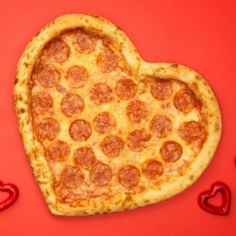 širdies formos pica pepperoni Valentino dienai raudono popieriaus fone
